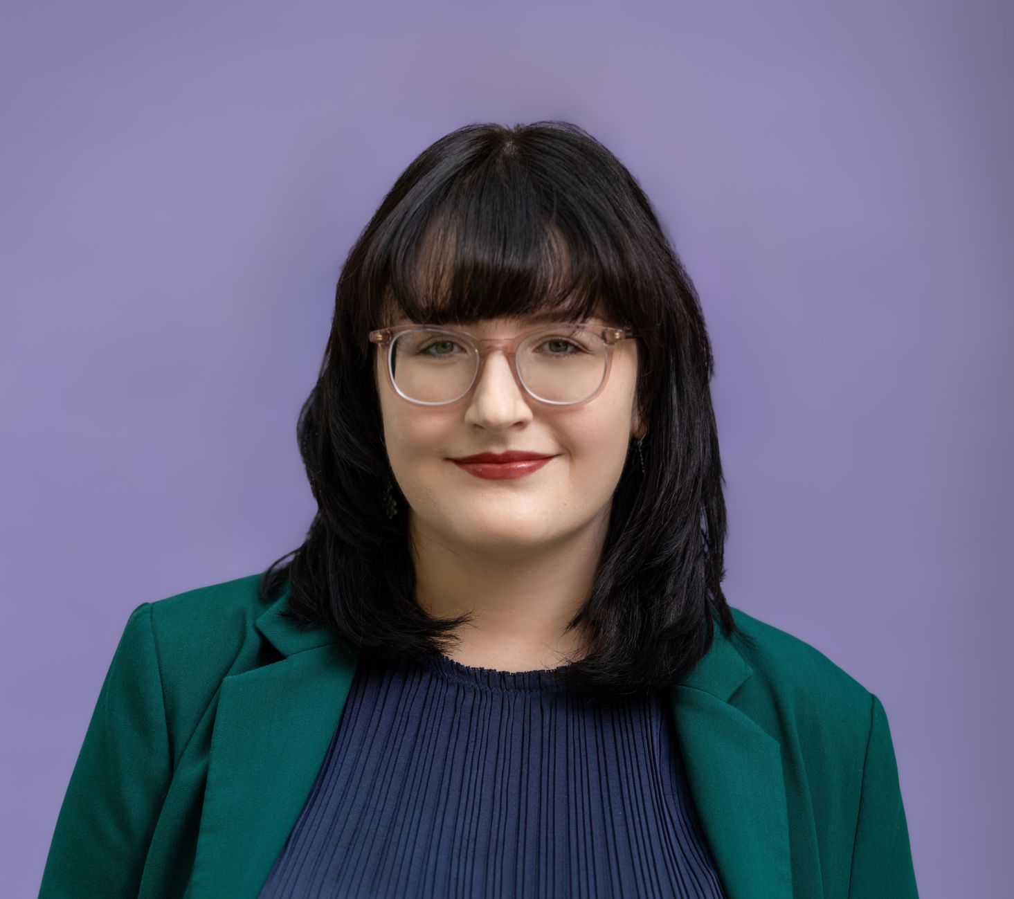 Nina smiling slightly, purple background.